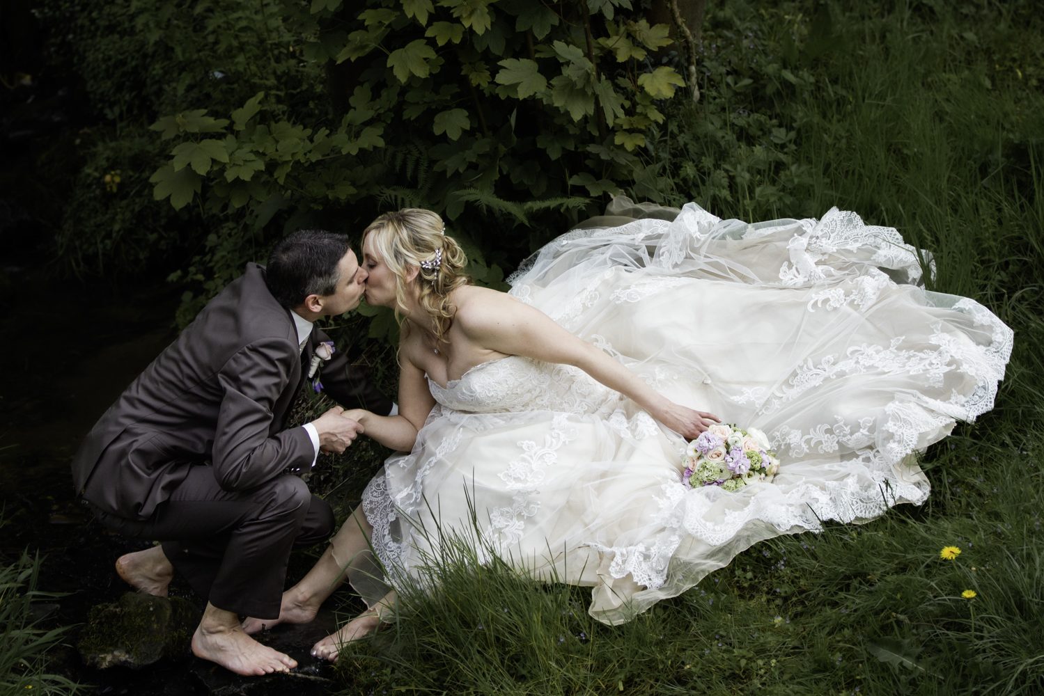 Braut und Bräutigam Hand in Hand im Garten – romantische Hochzeitsfotografie mit natürlicher Kulisse und authentischen Momenten Brautpaar in einem romantischen Garten im Rathaus Königswinter läuft Hand in Hand. Ein Kastanienbaum blüht im Hintergrund.
